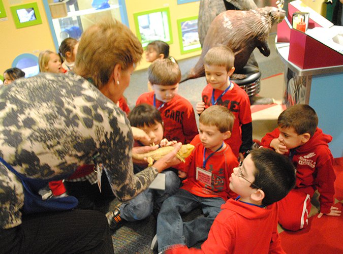 LICM educator showing a group of children a live bearded dragon.