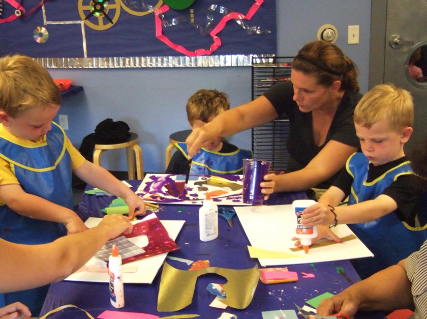 Adult and children complete a craft in Museum during Family Fun Night